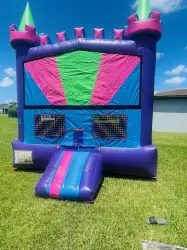 Purple, pink, blue and green bounce castle with hoop